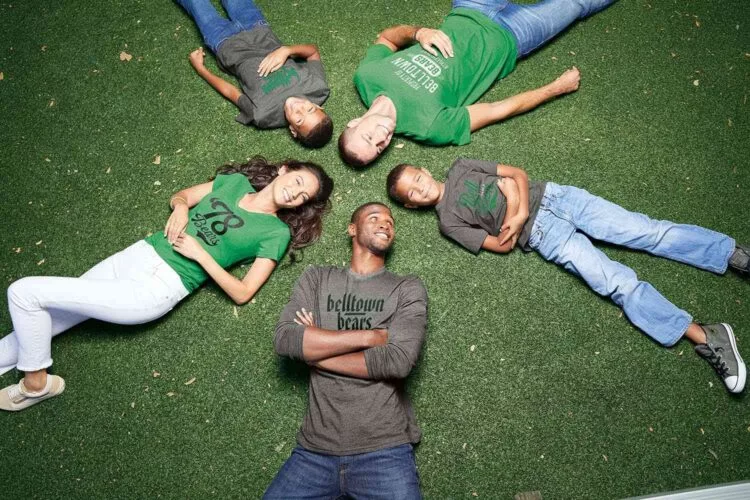group wearing custom tshirts laying on grass